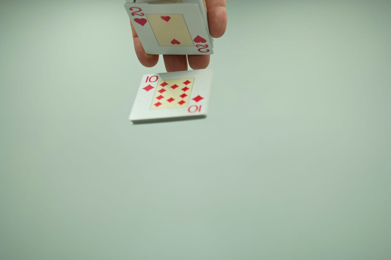 Mains d'un magicien tenant un jeu de cartes en éventail lors d'un cocktail de mariage en plein air